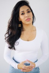 Author photo of Dr. Seema Yasmin wearing a white shirt and clasping hands